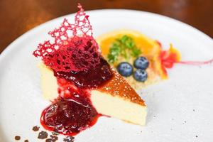 Cheese cake slice with raspberry sauce on withe plate - cheesecake fruit delicious dessert photo
