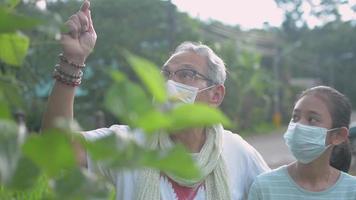Grandfather and granddaughter wearing face masks outside video