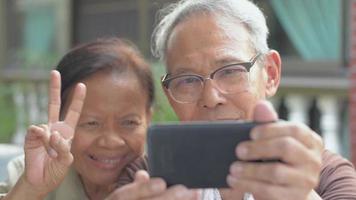 abuelos charlando con videollamadas en teléfonos inteligentes.