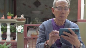 mujer abraza a hombre mayor que está viendo un video en un teléfono inteligente.