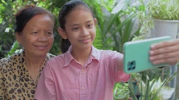 Teenage girl and her grandmother take a selfie. video