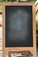 Black blackboard on wooden easel rubbed out dirty chalkboard on outdoors photo
