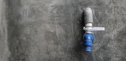 water faucet on the concrete wall photo