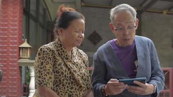 garota se junta aos avós que estão assistindo a vídeos sociais em um smartphone.