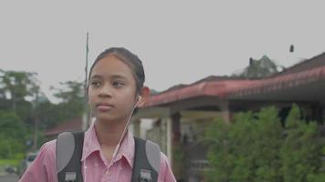 Schoolgirl listening to music while walking back home. video