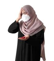 Muslim woman wearing a surgical mask feeling sick on white background