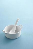 Ceramic spoon in cup on pastel background