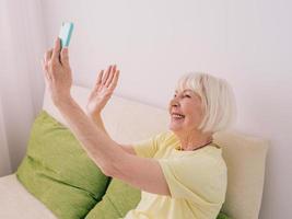 elderly cheerful caucasian stylish woman with gray happy to talk with family or friend by her smartphone at home. Technology, emotions, family, healthy lifestyle, positive thinking concept