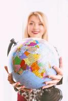 beautiful cheerful smiling blonde woman travel agent holding globe in her hands