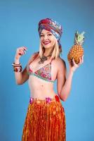 alegre mujer rubia sonriente en bikini en estilo tropical sobre fondo azul. viajes y cultura foto