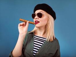 portrait of blonde beautiful woman in hat and sunglasses with cigar in cuban Che Guevara style