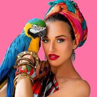 Portrait of young attractive woman in african style with ara parrot on her hand on colorful background photo