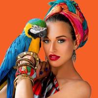 Portrait of young attractive woman in african style with ara parrot on her hand on colorful background photo