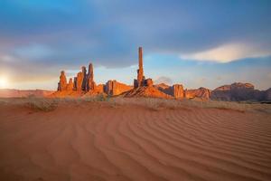 Totem pole and sand dunes  in Monument Valley, Arizona USA photo