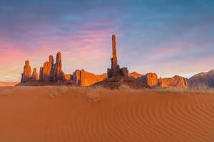 Totem pole and sand dunes  in Monument Valley, Arizona USA photo