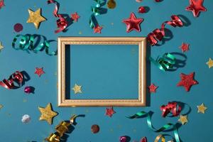 Top view golden frame with shiny festive stars, streamers, sparkles with copy space photo