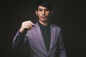 Businessman holding a pen, black background photo