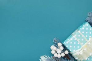 Fondo plano de navidad con regalos, bayas y pino espacio de copia de fondo turquesa foto