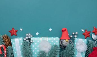 Fondo plano de Navidad con regalos, bayas y espacio de copia de telón de fondo turquesa de pino