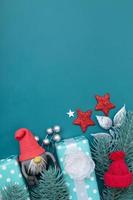 Tarjeta de felicitación de Navidad con decoraciones de vacaciones de invierno laicas planas sobre fondo turquesa con espacio de copia