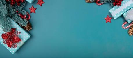 Fondo plano de navidad con regalos, flor de pascua y pino sobre fondo turquesa