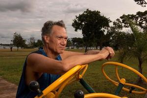 Senior hombre maduro trabajando en un gimnasio al aire libre en el parque das garcas, brasilia foto