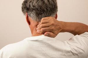 Senior Man in pain with Headache rubbing the back of his neck
