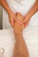 terapeuta de masaje masajeando un pie de señoritas