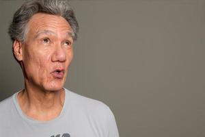 Portrait of a Senior Man having fun making faces and gestures photo