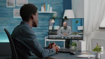 mise au point sélective sur un homme noir utilisant une conférence vidéo en ligne parlant avec son collègue de travail video