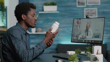 Hombre afroamericano en una llamada de videoconferencia con su médico mediante la aplicación médica de Internet video