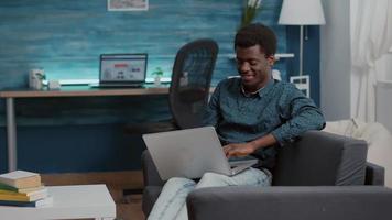 sobrecarregado, sobrecarregado de trabalho, exausto, homem afro-americano, sofrendo de privação de sono, adormecendo com o laptop na frente dele video