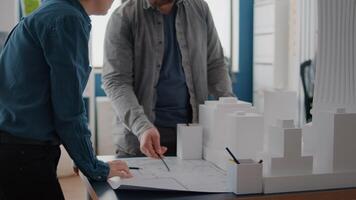 hombre y mujer mirando planos plan en papel para diseñar el modelo de construcción y maqueta video