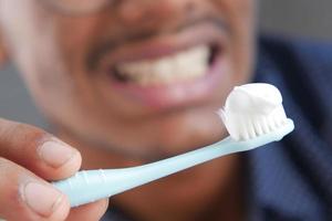 detail shot of young man brushing teeth, photo