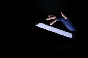 Close up of hacker hand stealing data from digital tablet photo
