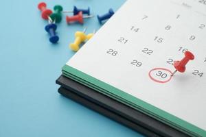 Concepto de fecha límite con alfiler en la fecha del calendario de cerca foto