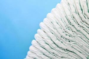 stack of baby diaper on blue background with copy space photo
