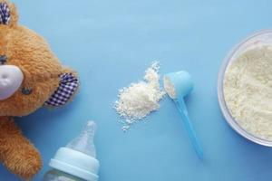 Close up of baby milk powder and spoon on tile background. photo