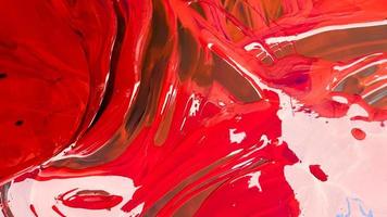 Abstract background of spilled red paint with buckets on a black backdrop. Red paint is pouring on a black background. Use it for an artist or creative concept. paints spilled red colored background photo