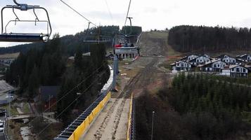 Ucrania, Bukovel - 20 de noviembre de 2019. Vista otoñal de la estación de esquí con un telesilla en el contexto de las pistas de montaña otoñales y la infraestructura en construcción de una estación de esquí de invierno. foto