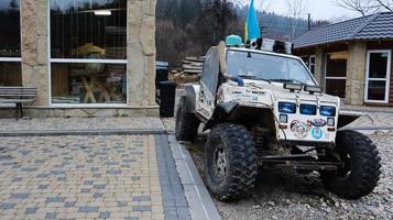 Ukraine, Bukovel - November 20, 2019. buggies with stickers and a blue-yellow flag in the parking lot of the resort town of Bukovel in western Ukraine. small light SUV. photo