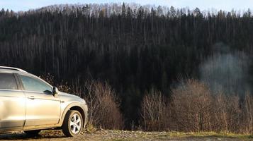 Ucrania, Yaremche - 20 de noviembre de 2019. Un jeep está estacionado con una cordillera al fondo. el coche está en las montañas de los cárpatos ucranianos en la pequeña ciudad de yaremche. foto