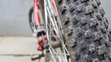 Close-up rear bicycle wheel of a parked mountain red bicycle. rear view old bicycle wheel texture vintage style. photo