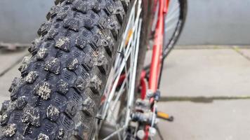 Close-up rear bicycle wheel of a parked mountain red bicycle. rear view old bicycle wheel texture vintage style. photo