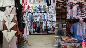 Souvenir market in Yaremche with traditional Carpathian handmade clothing, herbs and wooden tools. Ukrainian textiles, knitted socks, vests, hats. Ukraine, Yaremche - November 20, 2019 photo