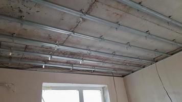 False ceiling design, before installing drywall. Plasterboard ceiling of a house at a construction site, installation of a false ceiling in a square room photo