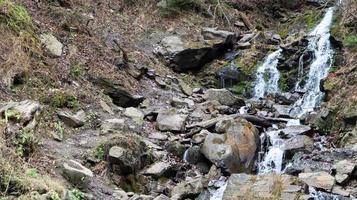 Waterfalls in a small canyon with stone walls. Beautiful cascade in the mountains. river in the Carpathians in the mountain autumn forest. scenic view, the movement of water. photo