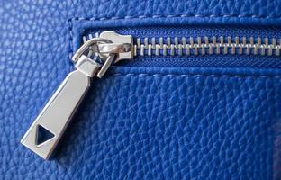 Natural or artificial leather texture. Fragment of a blue bag with a zipper and stitching. Zipper or clasp bag design element. Bovine skin texture with snake. Macro photo, selective focus. photo