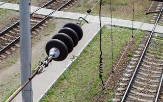 A railroad overhead power line component along a track with a rail electrification system that supplies power to an electric train. Overhead line wire on a rail track. photo