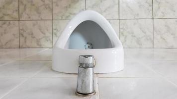 baño público con un urinario de cerámica. Los urinarios preparan cuencos para hombres.